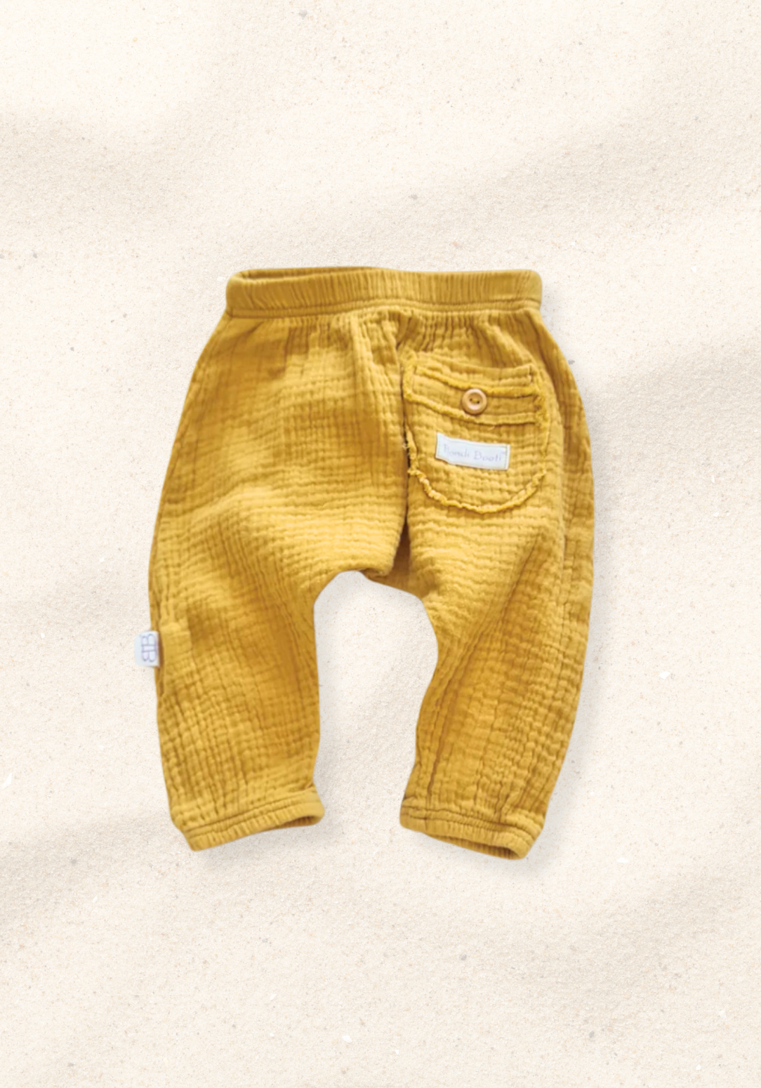 Toddler harem pants in mustard yellow made from organic cotton with a wooden button and soft elastic waistband
