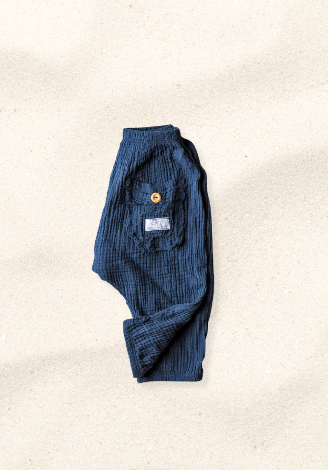Toddler harem pants in navy blue made from organic cotton with an elastic waistband and buttoned pocket