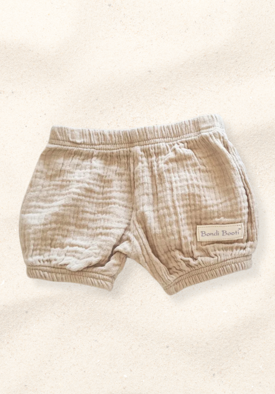 Neutral beige baby bloomers made of breathable organic cotton with gentle elastic trims.