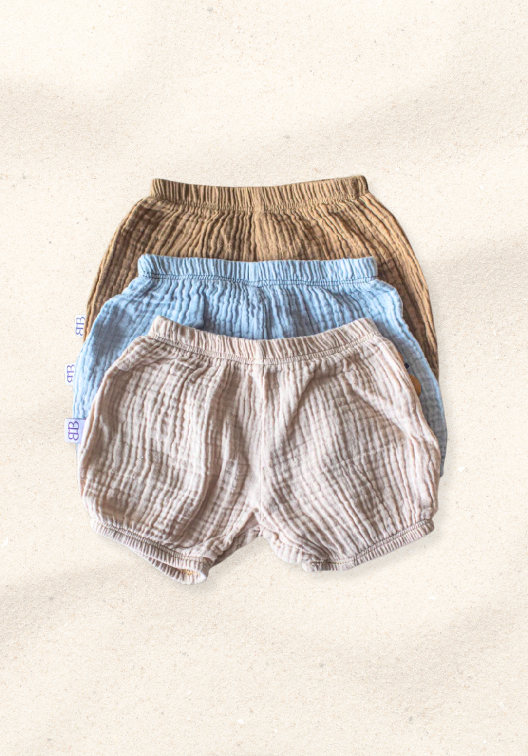 Neutral beige baby bloomers made of breathable organic cotton with gentle elastic trims.
