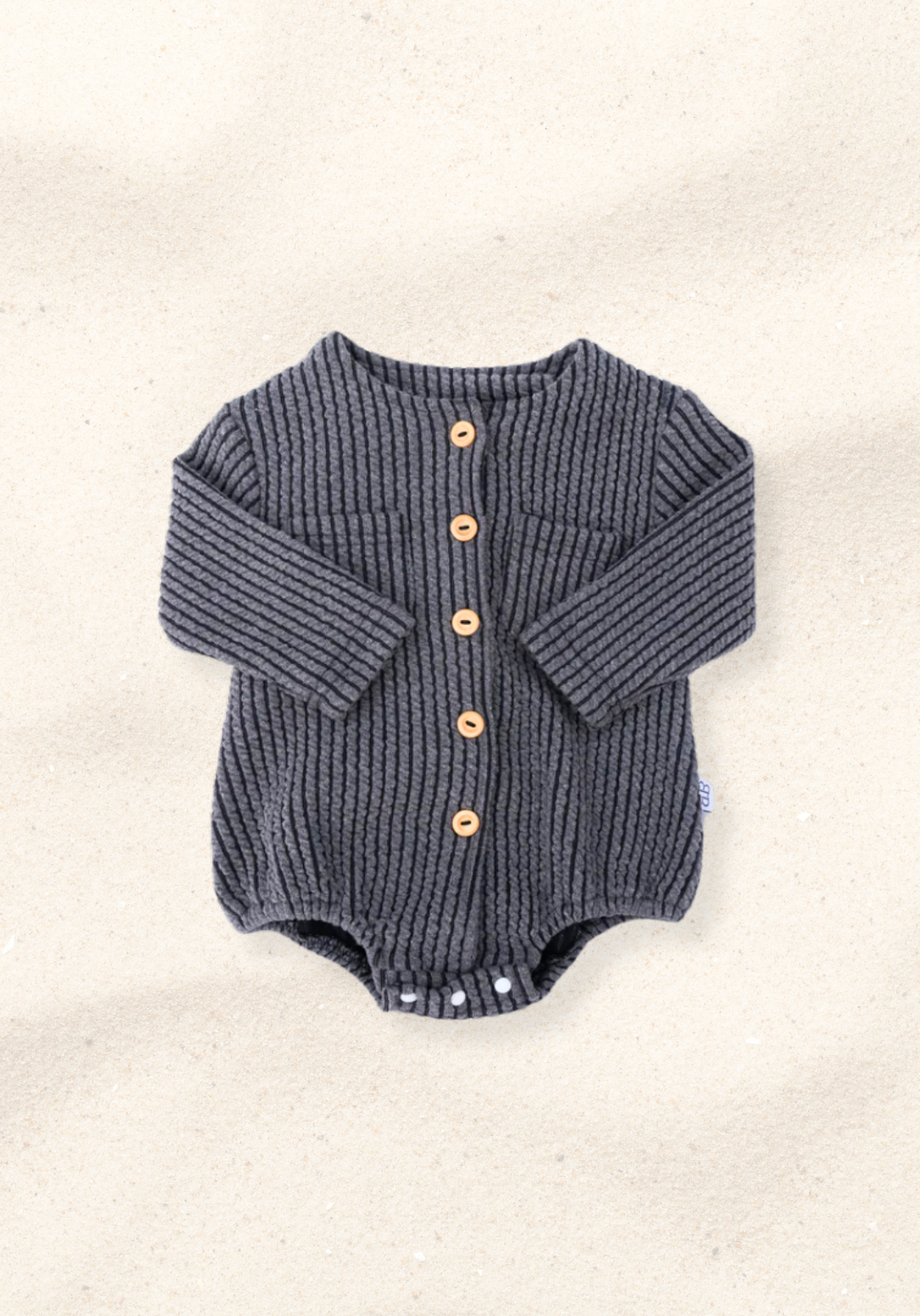 Charcoal cotton baby bubble romper with long sleeve design and gathered leg openings with three snap buttons at the bottom