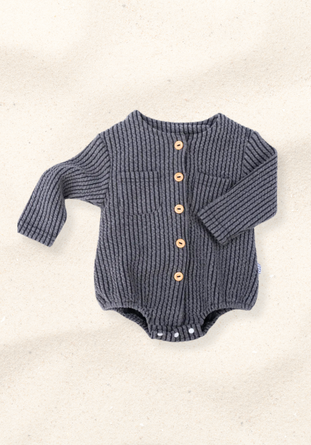 Charcoal cotton baby bubble romper with long sleeve design and gathered leg openings with three snap buttons at the bottom