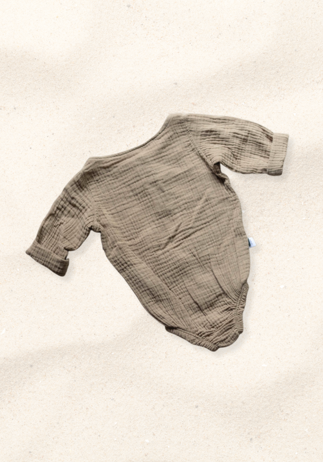 Long sleeve baby romper in mocha color crafted from organic cotton with snap closure and wood button details
