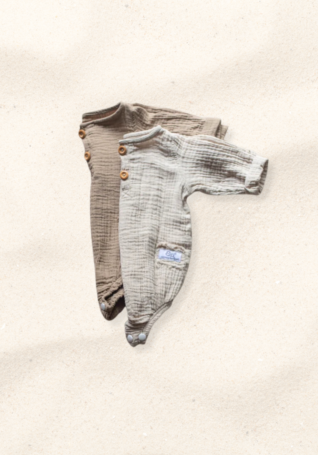 Long sleeve baby romper in mocha color crafted from organic cotton with snap closure and wood button details